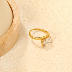 Detail view of square white zircon ring with four-claw setting on golden band