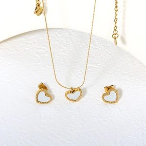 Set di gioielli a cuore dorato con inserto in conchiglia bianca e bordo perlato