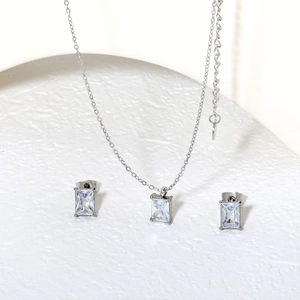 Minimalistisches Set aus Halskette und Ohrringen mit Zirkonia auf weißem Steinsockel