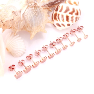 Set di 6 paia di orecchini a lobo a fiore in oro rosa su sfondo bianco con conchiglie