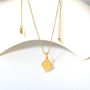 Collier minimaliste en or 18K avec pendentif soleil et lune sur présentoir blanc