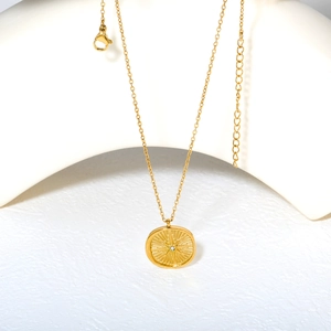 Détail du collier doré avec pendentif étoile et cristal sur support blanc élégant