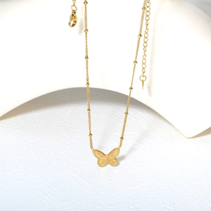 Collier élégant avec pendentif papillon doré 18K et chaîne perlée sur support artistique
