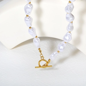Détail d'un collier en perles baroques avec perles dorées et fermoir à bascule OT