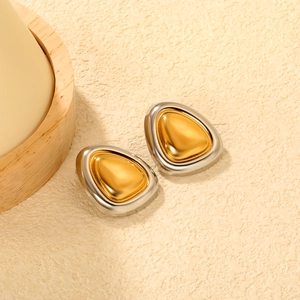 Makro-Detail geometrischer Bicolor-Ohrstecker mit poliertem Gold- und Silber-Finish