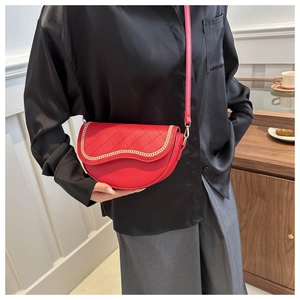 Detalle de bolso montura rojo con acolchado de diamantes y cadena dorada fina