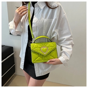 Detail of neon green quilted crossbody bag with heart crown metal buckle and top handle