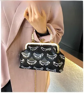 Detail of vintage black sequin evening bag with ornate golden handle and chain strap