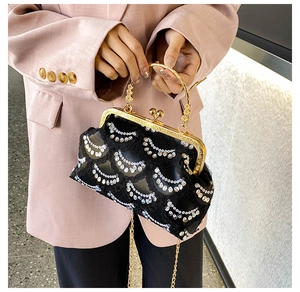 Detail of black sequined evening bag with gold metal frame and vintage handles