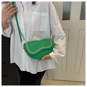 Detalle del bolso de silla acolchado verde esmeralda con cadena dorada y correa de cuero