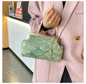 Detail of green lace sequin evening bag with vintage metal frame and chain strap