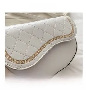 Detalle del bolso de silla acolchado blanco con bordado de cadena dorada y costuras finas
