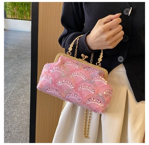 Detailed shot of pink sequin evening bag with golden carved handle and chain