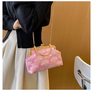 Pink lace sequin evening clutch bag with gold chain strap worn as crossbody