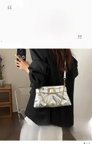 Détail du sac argenté métallisé avec fermoir doré et texture froncée style nuage