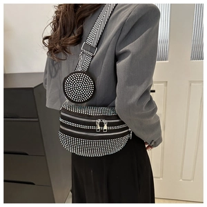 Detail der schwarzen Strass-Brusttasche mit gemustertem Gurt und kleinem runden Münzfach