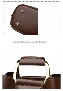 Detail view of gold metal protective studs and stitched leather handle on a brown bucket bag