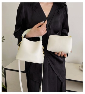 Détail d'un sac seau blanc avec poignée en résine et sa pochette assortie