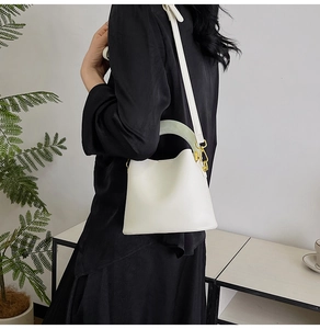 Détail du sac seau blanc avec poignée en résine verte et bandoulière réglable