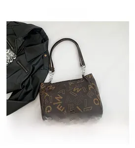 Detail of coffee tote bag featuring monogram prints and silver chain leather shoulder strap