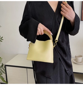 Détail du sac seau crème avec poignée en résine ambre et bandoulière en cuir
