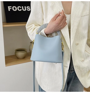 Gros plan du sac seau bleu clair avec poignée effet marbre et finitions en métal doré