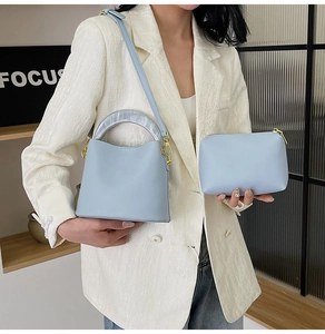 Détail du sac seau bleu clair avec poignée en résine marbrée et pochette assortie