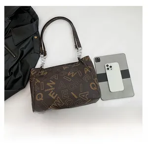 Top view of brown vintage tote bag with chain strap next to tablet for size scale