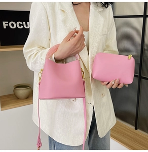 Vue détaillée du sac seau rose avec poignée en résine et pochette assortie sur mannequin