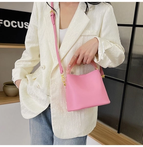 Détail d'un sac seau rose avec poignée en résine et bandoulière réglable