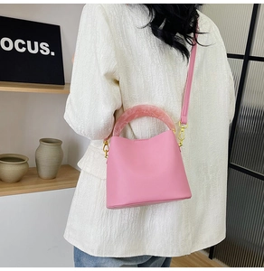 Détail du sac seau rose avec poignée en résine marbrée et boucle de verrouillage dorée