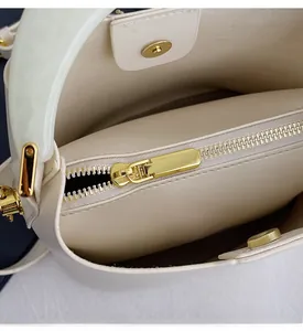 Détail de la fermeture éclair dorée et du fermoir magnétique du sac seau blanc