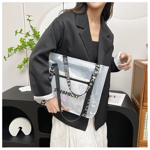 Transparent PVC tote bag with stylish black lettered shoulder strap shown on model