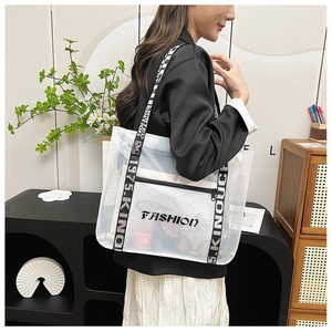Detail of transparent PVC tote bag featuring black interior pocket and printed logo