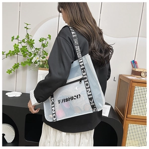 Detail view of transparent PVC tote bag with black lettered straps and FASHION logo