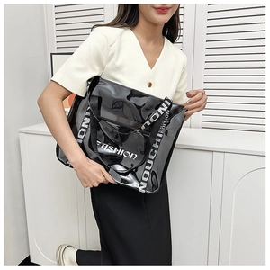 Close-up of semi-transparent black PVC tote with FASHION text and jacquard strap