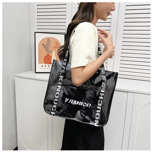 Detail of transparent black PVC tote bag with striped straps and fashion lettering