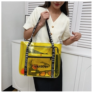Detail of yellow transparent tote bag with limited edition lettered straps on a model