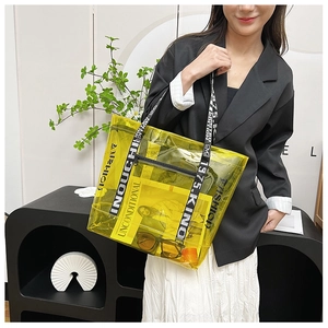 Detail view of yellow transparent PVC tote bag with stylish lettered shoulder straps