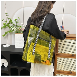 Detail of transparent yellow PVC tote bag with stylish letter print shoulder strap
