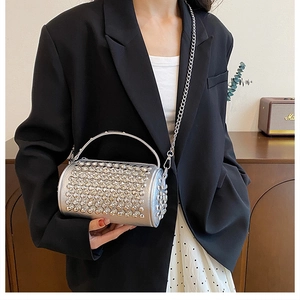 Close-up of sparkling silver rhinestone cylinder bag with metallic handle and chain strap