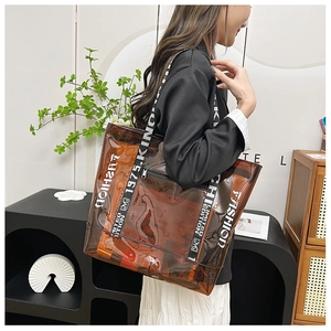 Detail view of large brown transparent PVC tote bag with stylish printed webbing strap