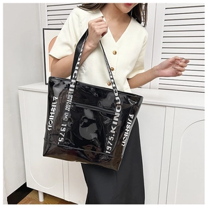 Detail of black tote bag featuring high-gloss finish and fashion letter print straps