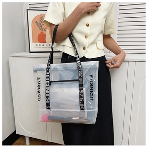 Detailed view of transparent PVC tote bag with Fashion lettering and black nylon straps