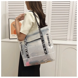 Detail of transparent PVC tote bag with black letter print and woven shoulder strap