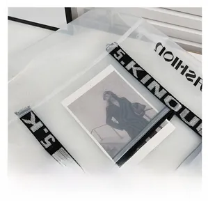 Detail of transparent PVC tote bag with black lettered woven strap and smooth texture