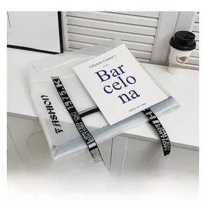 Detail of transparent PVC tote bag featuring black fashion print and wide woven strap