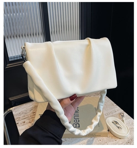 Detail of off-white pleated cloud bag with soft faux leather texture and shoulder strap