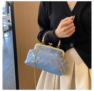 Détail de sequins irisés bleu clair et fermoir en métal doré sur un sac à main chic
