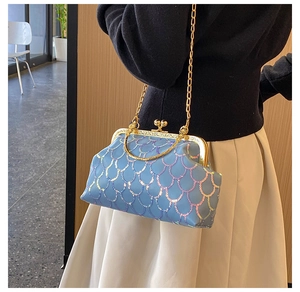 Dettaglio ravvicinato delle paillettes a scaglie iridescenti sulla borsa da sera azzurra